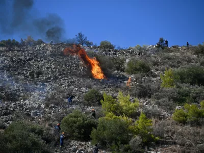 Firefighters battle a wildfire on the island of Salamina, west of Athens, Greece, Sunday, Aug. 16, 2026. (AP Photo/Michael Varaklas)