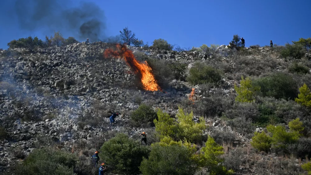 Firefighters battle a wildfire on the island of Salamina, west of Athens, Greece, Sunday, Aug. 16, 2026. (AP Photo/Michael Varaklas)