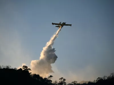 A firefighting airplane drop water during a wildfire on the island of Salamina, west of Athens, Greece, Sunday, Aug. 16, 2026. (AP Photo/Michael Varaklas)