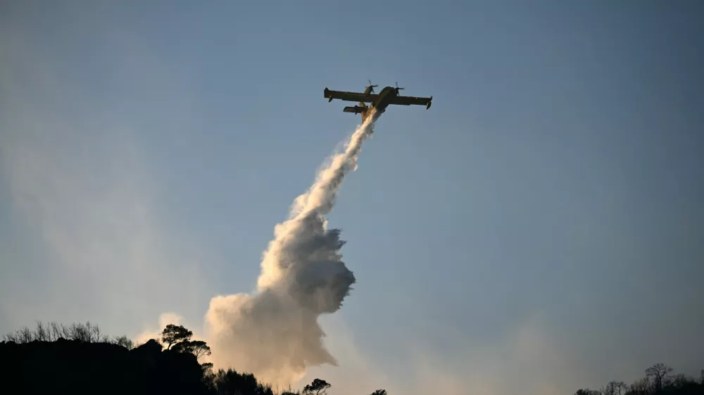 A firefighting airplane drop water during a wildfire on the island of Salamina, west of Athens, Greece, Sunday, Aug. 16, 2026. (AP Photo/Michael Varaklas)