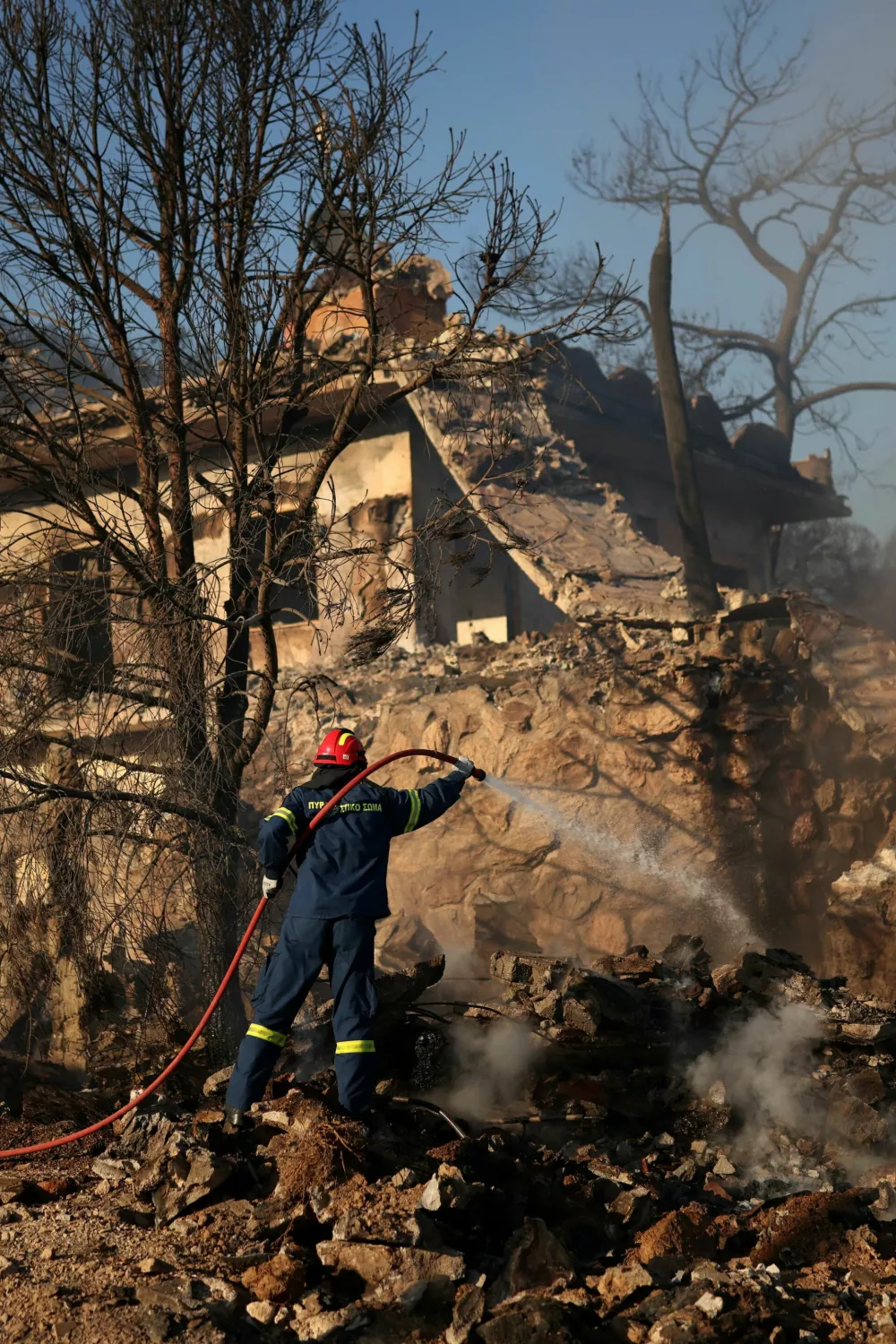 A firefighter battles a wildfire in Peristeria area, Salamina island, near Athens, Greece, August 16, 2026. REUTERS/Stelios Misinas
