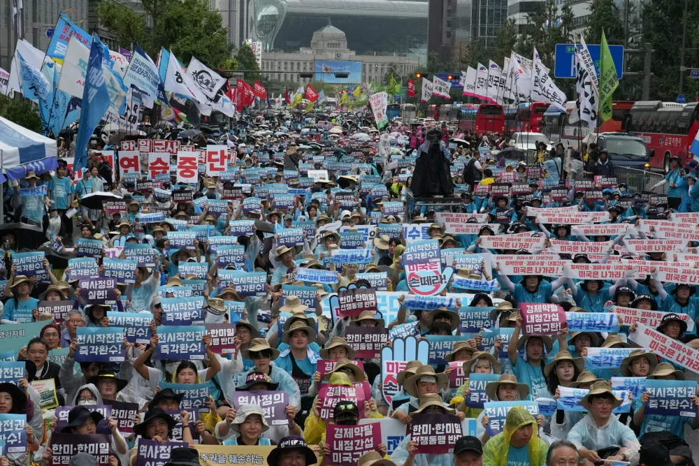 Protesters hold signs during a rally demanding peace on the Korean Peninsula in Seoul, South Korea, Saturday, Aug. 15, 2026. (AP Photo/Lee Jin-man)