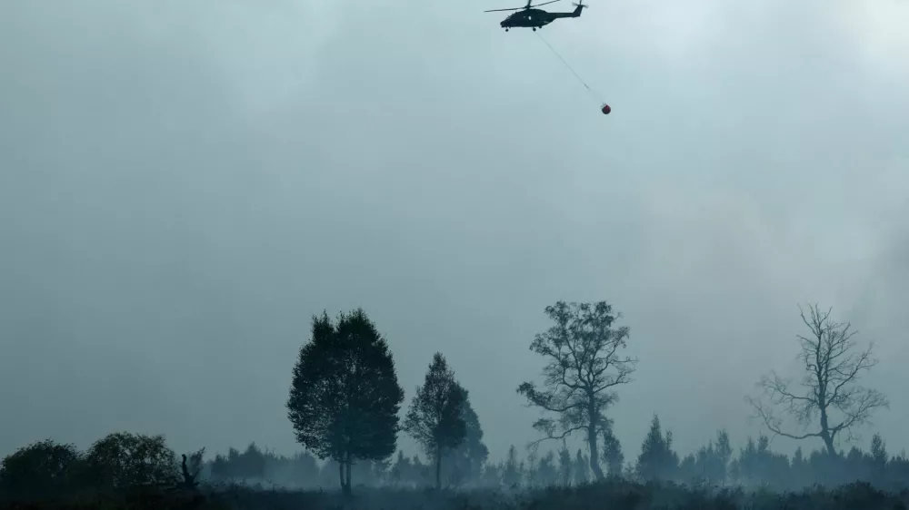 A Belgian Army helicopter flies over the area affected by a wildfire, near Waimes, in the High Fens (Hautes Fagnes) region, Belgium, August 17, 2026. REUTERS/Yves Herman