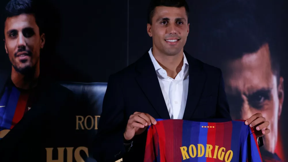 Barcelona's Rodri poses with his jersey during his official presentation at a soccer press conference in Barcelona, Spain, Tuesday, Aug. 18, 2026. (AP Photo/Joan Monfort)