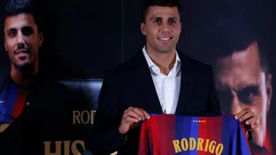 Barcelona's Rodri poses with his jersey during his official presentation at a soccer press conference in Barcelona, Spain, Tuesday, Aug. 18, 2026. (AP Photo/Joan Monfort)