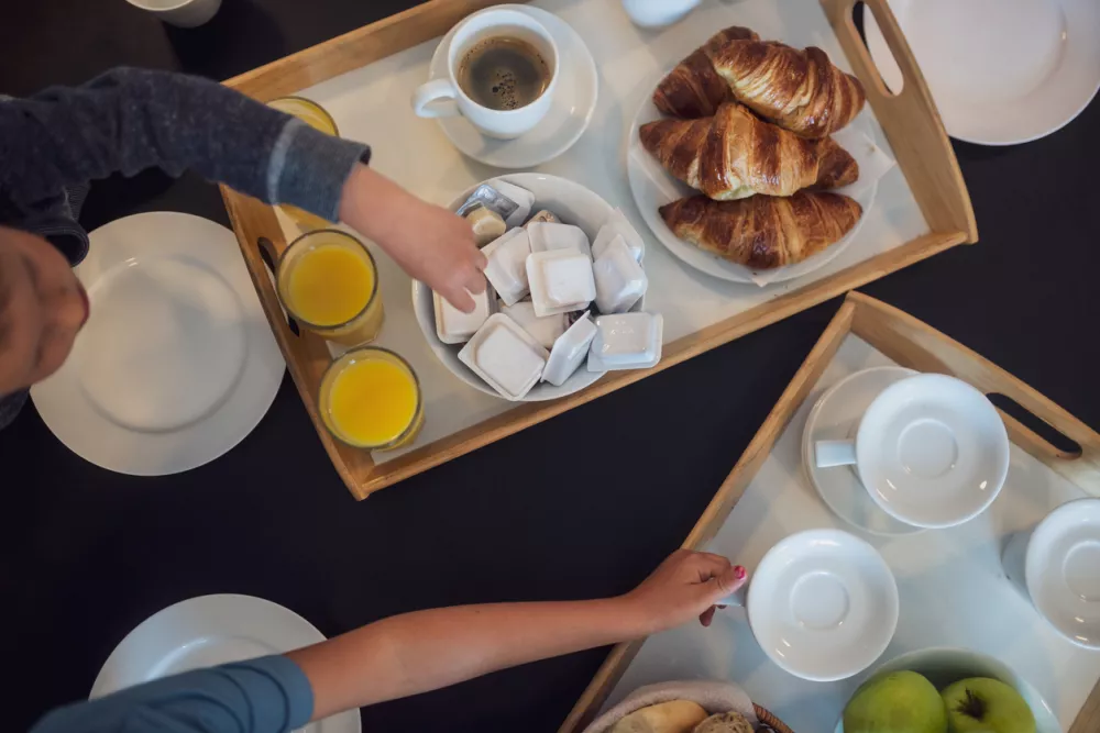 Top view of breakfast being served in a hotel with kids reaching for the delicious food served. / Foto: Gajus Getty Images/istockphoto