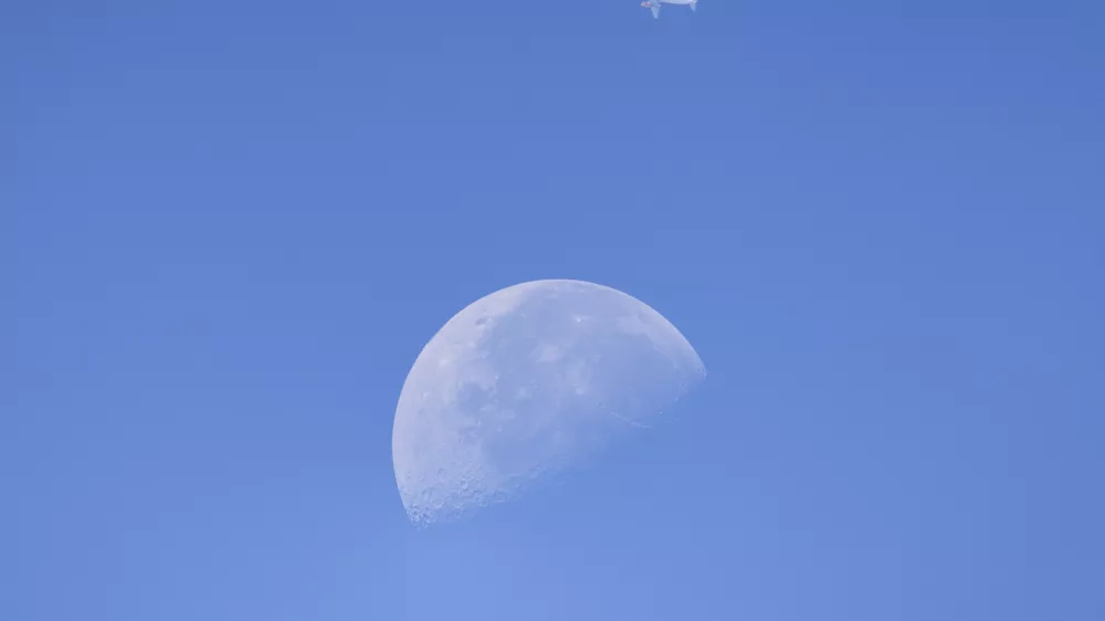 A commercial aircraft passes in front of the Moon above Sofia, Bulgaria, on August 5, 2026. The photograph was taken as astronomers and skywatchers observed the widely anticipated impact of a SpaceX Falcon 9 upper stage with the lunar surface during a closely followed space event.