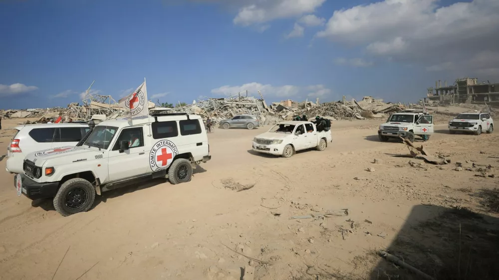 Red Cross personnel, escorted by Hamas militants, wait to head towards an area within the so-called "yellow line" to which Israeli troops withdrew under the ceasefire, as Hamas says it continues to search for the bodies of deceased hostages seized during the October 7, 2023, attack on Israel, in Gaza City November 12, 2025. REUTERS/Dawoud Abu Alkas