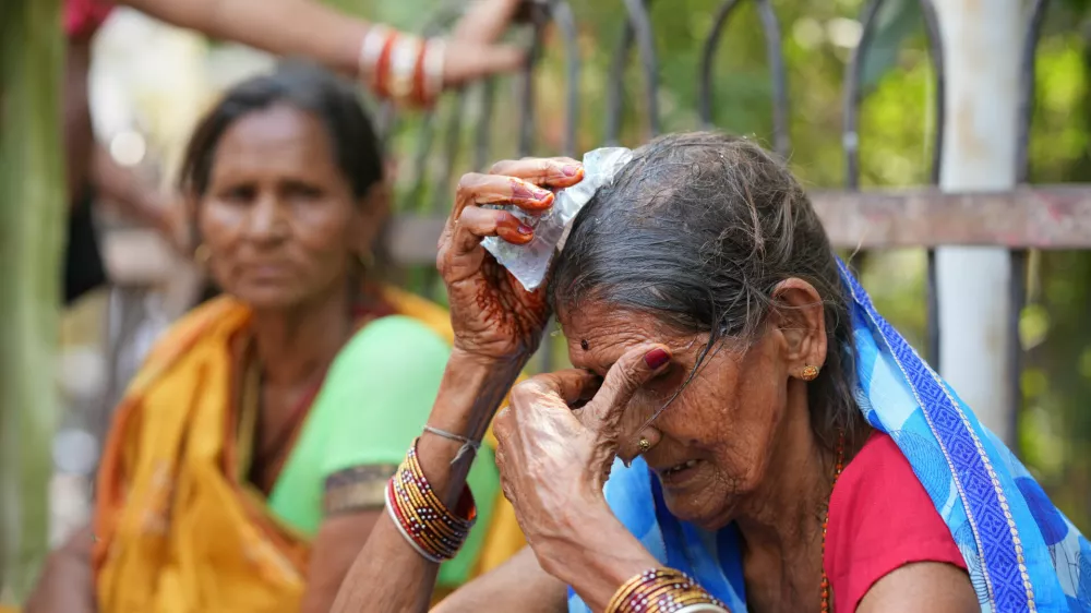 A woman cools herself off with an ice pack during a heat wave in Banda, northern Indian state of Uttar Pradesh, Sunday, June 21, 2026. (AP Photo/Rajesh Kumar Singh)