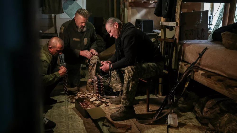 Serhii Krynitskyi, 42, a serviceman of the 24th Separate Mechanized Brigade of the Ukrainian Armed Forces, who spent 346 days at an isolated frontline position in the town of Chasiv Yar, Donetsk region, helps his fellow soldiers load machine gun cartridges on his first day back on duty after recovery, amid Russia's attack on Ukraine, in the frontline city of Kramatorsk in Donetsk region, Ukraine, May 27, 2026. REUTERS/Alina Smutko