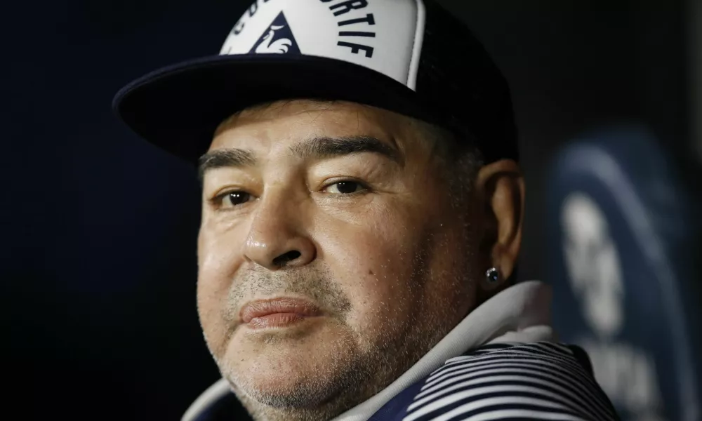 FILE - In this March 7, 2020 file photo, Diego Maradona, coach of Gimnasia y Esgrima, sits on the bench prior to Argentina's soccer league match against Boca Juniors at La Bombonera stadium in Buenos Aires, Argentina. Maradona turns 60 on Friday, Oct. 30, 2020. (AP Photo/Natacha Pisarenko, File)