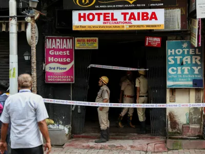 Firefighters stand at an entryway to a hotel where a fire broke out and killed several people, in Kolkata, India, August 19, 2026. REUTERS/Sahiba Chawdhary