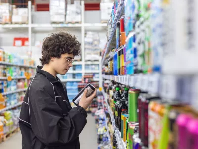 Adolsent boy reading beverage label while shopping in supermarket. unhealthy beverage habits and health risk