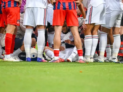 Bayern's Jamal Musiala, center, sits on the ground during a friendly soccer match between FC Heidenheim and FC Bayern Munich in Heidenheim, Germany, Tuesday, Aug. 18, 2026. (Harry Langer/DeFodi/dpa via AP)