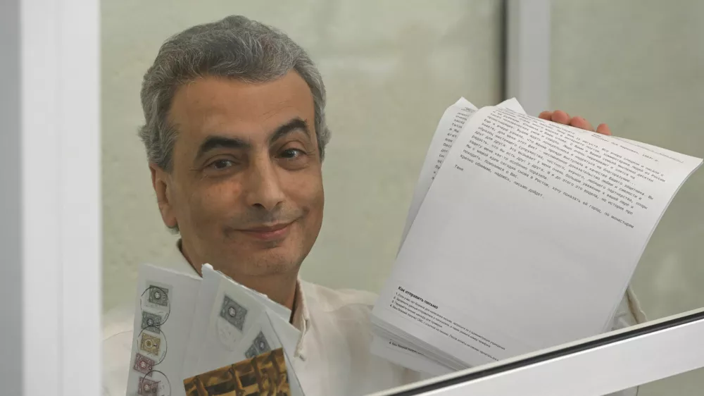 Lev Shlosberg, 2nd right, senior member of the Yabloko party, stands in the defendant's box prior to a verdict in the case against him is delivered, in a court in Pskov, Russia, Monday, Aug. 17, 2026. (AP Photo)