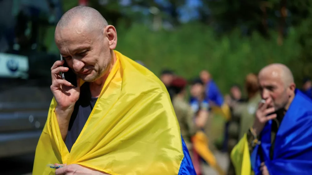 A Ukrainian prisoner of war (POW) reacts while he speaks with relatives via a phone after a swap, amid Russia's attack on Ukraine, at an undisclosed location in Ukraine August 19, 2026. REUTERS/Valentyn Ogirenko