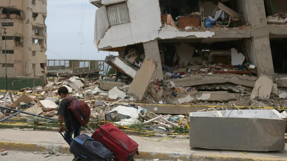 A child carries suitcases outside a Mision Vivienda housing building damaged by the June 24 earthquakes, in Catia la Mar, La Guaira state, Venezuela, July 9, 2026. REUTERS/Leonardo Fernandez Viloria / Foto: Leonardo Fernandez Viloria