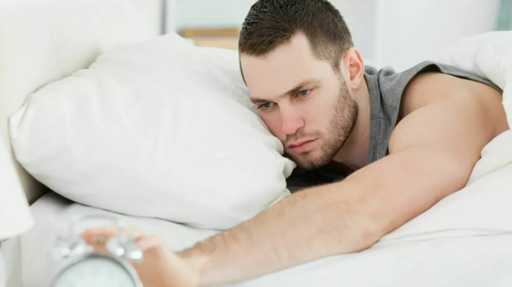 Man waking up in his bedroom