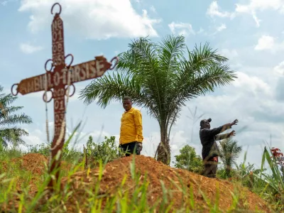 FILE PHOTO: Charles Mambo, the supervisor at the Ceca-20 cemetery, flanked by Moise Mund'wa, the assistant warden of the cemetery, talks near graves during an interview with Reuters, as aid agencies intensify efforts to contain an Ebola outbreak caused by the Bundibugyo virus, in the Ebola hit Mungwalu, Djugu Territory of Ituri province, Democratic Republic of Congo, July 14, 2026. REUTERS/Gradel Muyisa Mumbere/File Photo / Foto: Gradel Muyisa Mumbere