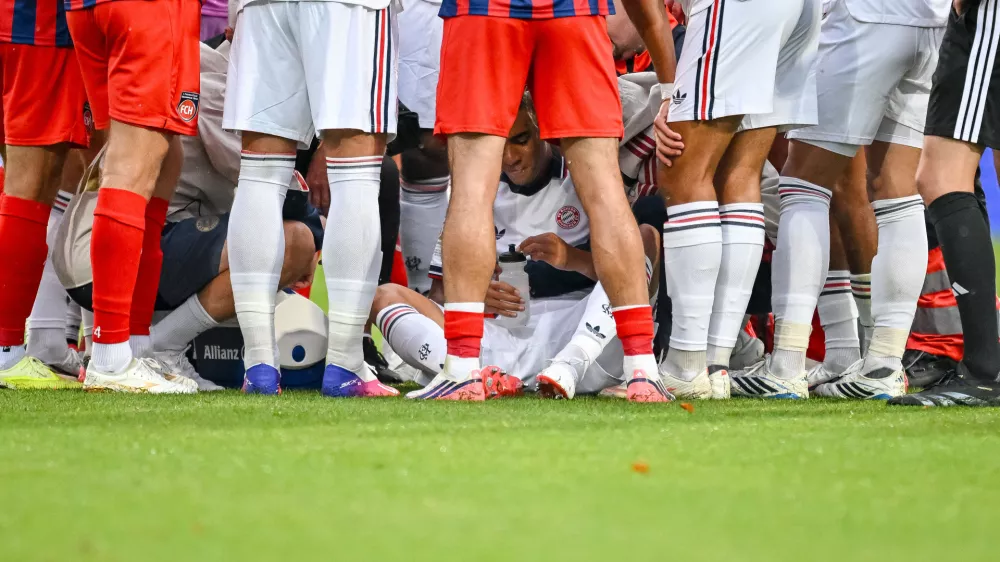 Bayern's Jamal Musiala, center, sits on the ground during a friendly soccer match between FC Heidenheim and FC Bayern Munich in Heidenheim, Germany, Tuesday, Aug. 18, 2026. (Harry Langer/DeFodi/dpa via AP)
