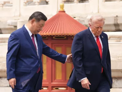 President Donald Trump, right, is assisted by Chinese President Xi Jinping at the Temple of Heaven on Thursday May 14, 2026, in Beijing. (AP Photo/Mark Schiefelbein)