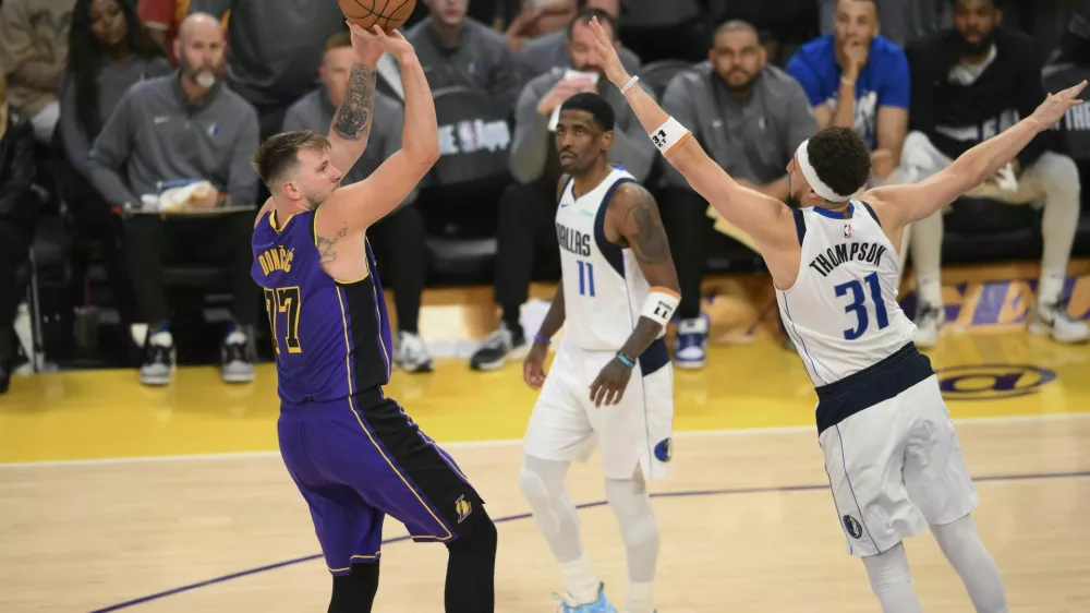 Los Angeles Lakers guard Luka Doncic (77) shoots over Dallas Mavericks guard Klay Thompson (31) during the second half of an NBA basketball game Tuesday, Feb. 25, 2025, in Los Angeles. (AP Photo/Kyusung Gong)