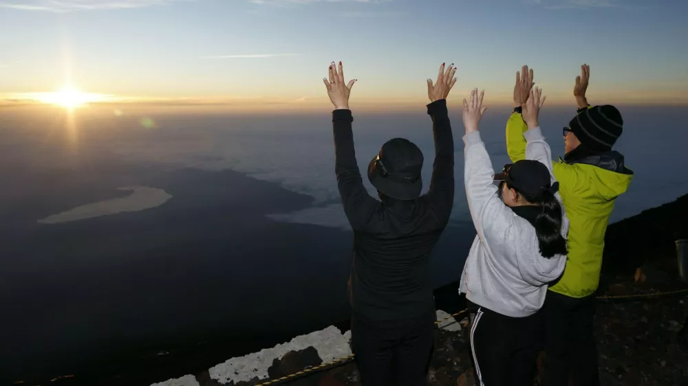 Climbers atop Mt. Fuji hail the sunrise on July 1, 2025, the day the mountain's Yoshida trail opened as the official climbing season began for Japan's highest mountain, straddling Shizuoka and Yamanashi prefectures.,Image: 1016624993, License: Rights-managed, Restrictions:, Model Release: no 