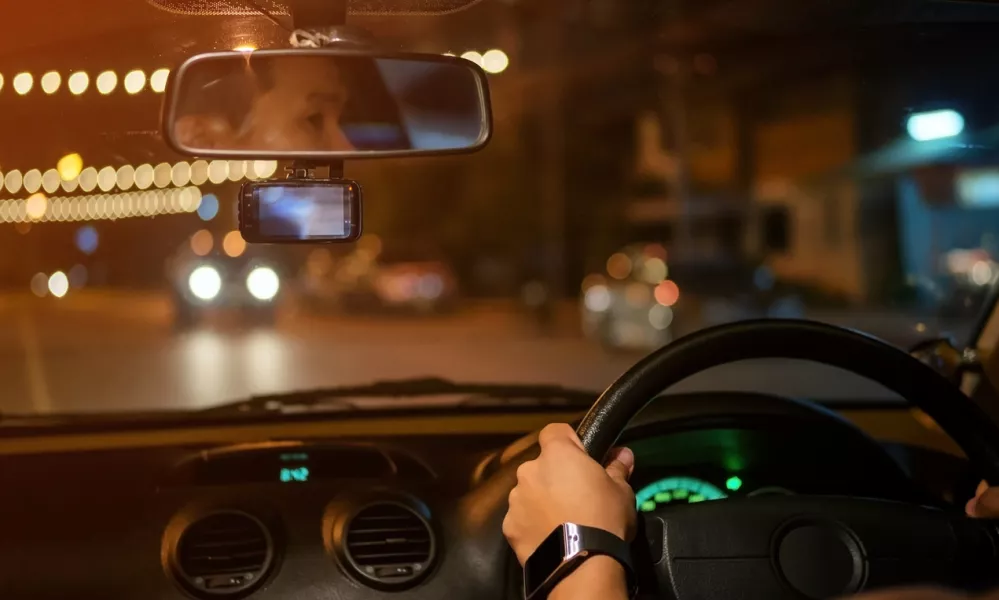 Men driving a car at night.