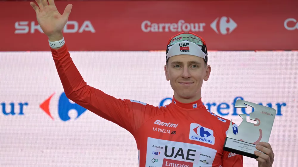 Slovenia's Tadej Pogacar, wearing the overall leader's red jersey celebrates on the podium after winning the first stage of the La Vuelta cycling race, a time trial with start and finish in Monaco, Saturday, Aug. 22, 2026. (AP Photo/Philippe Magoni)