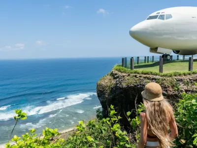 Blonde tourist admiring repurposed boeing 737 airplane on a cliff overlooking the indian ocean in bali,Image: 1001085464, License: Royalty-free, Restrictions:, Model Release: yes