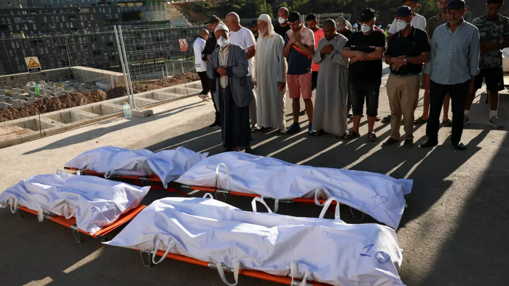 People pray during the funeral of migrants who died while trying to cross into Ceuta, at the city's Muslim cemetery, before burial in Ceuta, Spain, August 21, 2026. REUTERS/Violeta Santos Moura