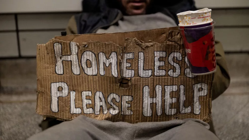 A homeless person holds a sign in an underground station as British Prime minister Andy Burnham has pledged to end rough sleeping, in London, Britain, August 21, 2026. REUTERS/Chris J. Ratcliffe  TPX IMAGES OF THE DAY