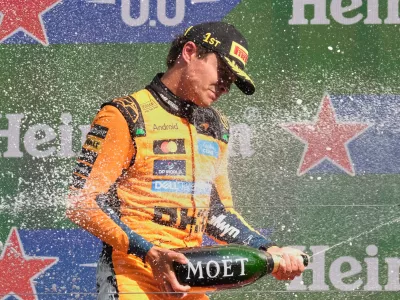 McLaren driver Lando Norris of Britain sprays champagne after winning the Formula One Dutch Grand Prix in Zandvoort, Netherlands, Sunday, Aug. 23, 2026. (AP Photo/Patrick Post)
