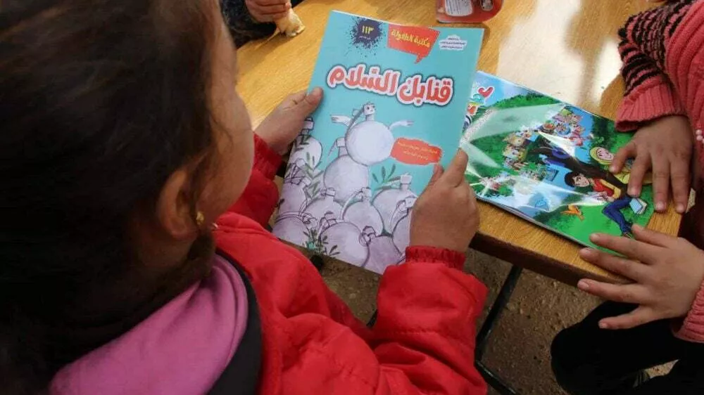 A-girl-reads-a-book-about-peace-in-a-camp-in-northern-Syria Foto: Sonia al-Ali