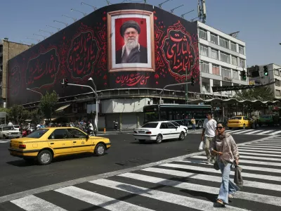 People walk past a billboard with an image of Iran's late Supreme Leader Ayatollah Ali Khamenei in Tehran, Iran, July 13, 2026. Majid Asgaripour/WANA (West Asia News Agency) via REUTERS ATTENTION EDITORS - THIS PICTURE WAS PROVIDED BY A THIRD PARTY. ISRAEL OUT. NO COMMERCIAL OR EDITORIAL SALES IN ISRAEL. NO ACCESS FOR ISRAELI MEDIA. NO USE BBC PERSIAN. NO USE VOA PERSIAN. NO USE MANOTO. NO USE IRAN INTERNATIONAL. NO USE RADIO FARDA. DIGITAL: NO USE BBC PERSIAN. NO USE VOA PERSIAN. NO USE MANOTO. NO USE IRAN INTERNATIONAL. NO USE RADIO FARDA.