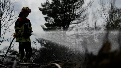 Romanian firefighters work to prevent a wildfire from reigniting as they tackle smoldering ground following a fire in the Deliblato Sands nature reserve, near Deliblato, Serbia, August 23, 2026. REUTERS/Djordje Kojadinovic   TPX IMAGES OF THE DAY
