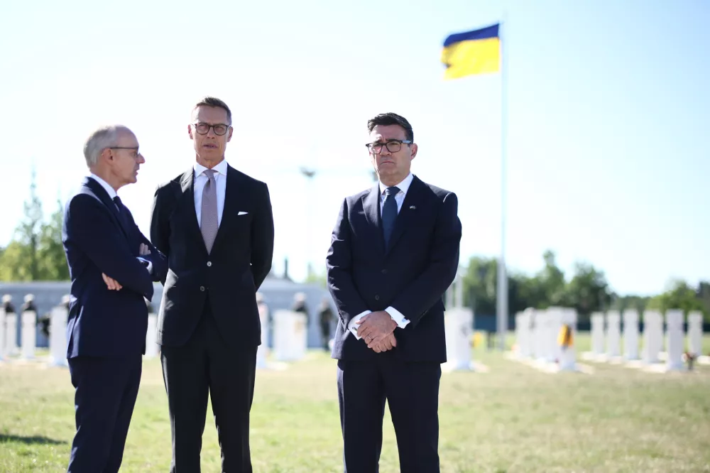 Luxembourg's Prime Minister Luc Frieden, from left, Finland's President Alexander Stubb and Britain's Prime Minister Andy Burnham take part in a wreath-laying ceremony at Ukraine's national military memorial cemetery in Hatne, southwest of Kyiv, Ukraine, Monday, Aug 24, 2026. (Henry Nicholls/Pool Photo via AP)
