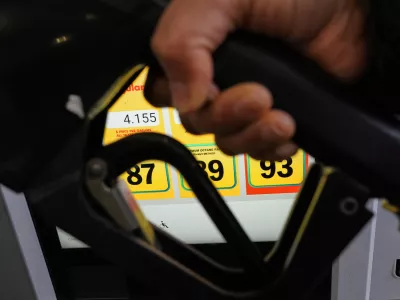 A person fills up her vehicle's gas tank at a gas station in Buffalo Grove, Ill., Thursday, April 2, 2026. (AP Photo/Nam Y. Huh)