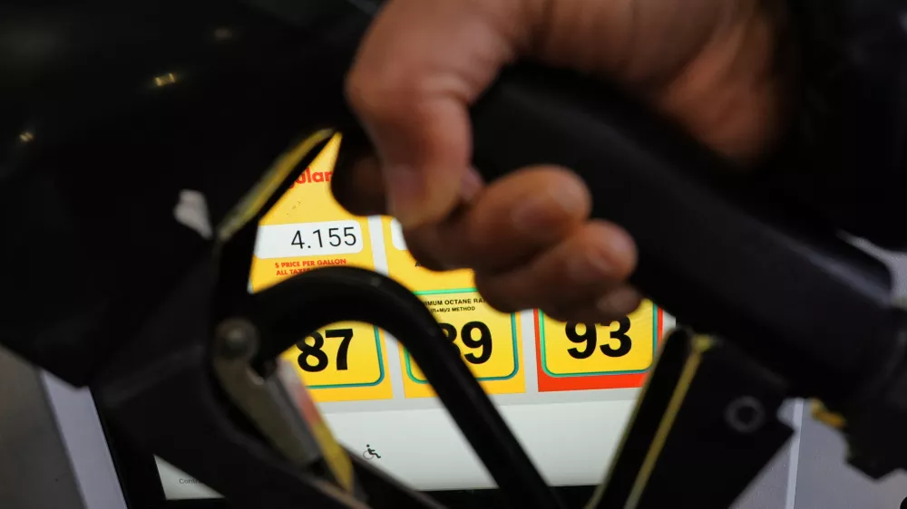 A person fills up her vehicle's gas tank at a gas station in Buffalo Grove, Ill., Thursday, April 2, 2026. (AP Photo/Nam Y. Huh)