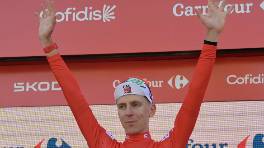 Slovenia's Tadej Pogacar, wearing the overall leader's red jersey celebrates on the podium after the second stage of the La Vuelta cycling race, with start in Monaco and finish in Manosque, France, Sunday, Aug. 23, 2026. (AP Photo/Philippe Magoni)
