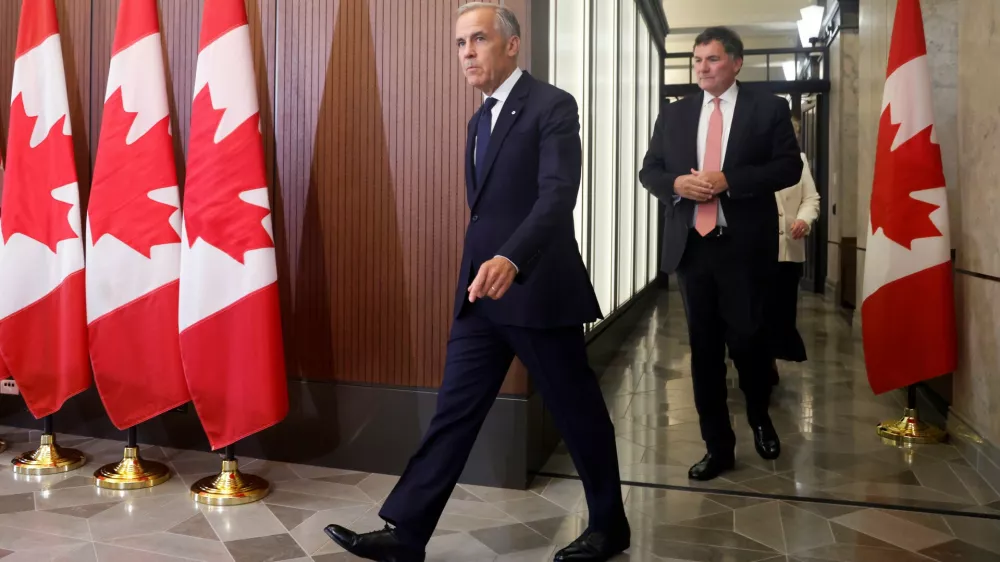 Prime Minister Mark Carney and Canada-U.S. Trade Minister Dominic LeBlanc arrive at a news conference about Canada's response to new U.S. tariffs on Parliament Hill in Ottawa on Saturday, Aug. 22, 2026. (Patrick Doyle/The Canadian Press via AP)