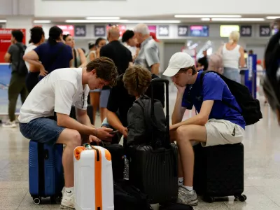 Passengers sit on their luggage in the check-in hall, a day after an ash cloud from Sicily's Mount Etna volcano drifted over Malta, forcing the cancellation of some flights to and from the Mediterranean island at the height of the tourism season, at Malta International Airport in Gudja, Malta, August 12, 2026. REUTERS/Darrin Zammit Lupi