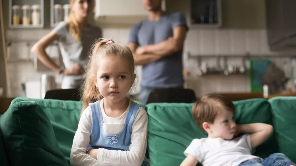 Frustrated kid girl feels upset, offended or bored ignoring avoiding worried parents and brother, little sad sister not talking to child boy after fight sulking sitting on couch, siblings rivalry