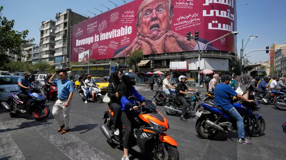 Motorcyclists pass a billboard depicting U.S. President Donald Trump with hands around his neck beneath the words "Revenge is inevitable" in Tehran, Iran, Monday, Aug. 24, 2026. (AP Photo/Vahid Salemi)