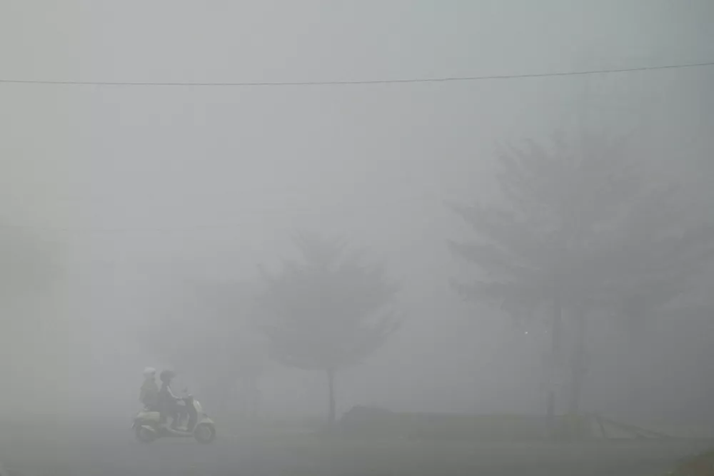 A motorist rides through a road shrouded in haze caused by wildfires in Banyuasin regency, South Sumatra province, Indonesia, August 23, 2026. REUTERS/Abriansyah Liberto