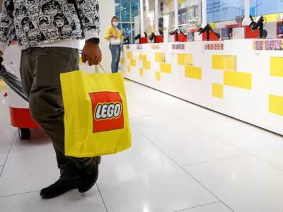 FILE PHOTO: A customer carries a bag while shopping in the 5th Avenue Lego store in New York City, U.S., September 28, 2021. REUTERS/Brendan McDermid/File Photo