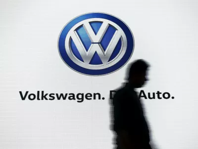 FILE PHOTO: A man walks past a screen displaying a logo of Volkswagen at an event in New Delhi, India, June 23, 2015. REUTERS/Anindito Mukherjee/File Photo