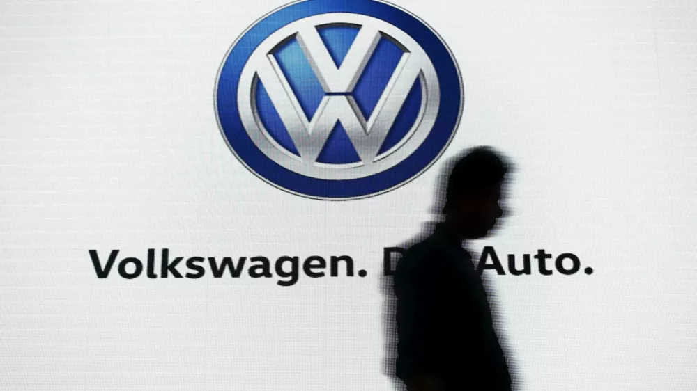 FILE PHOTO: A man walks past a screen displaying a logo of Volkswagen at an event in New Delhi, India, June 23, 2015. REUTERS/Anindito Mukherjee/File Photo
