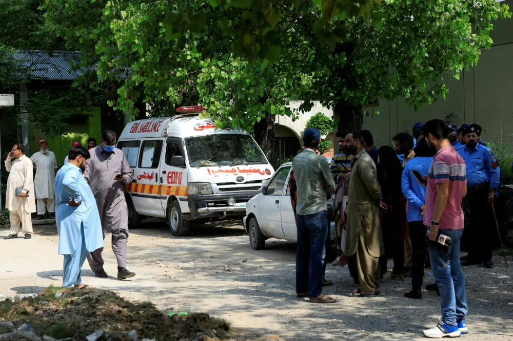 Family members and police officers stand outside a mortuary following a deadly fire at the Pakistan Institute of Medical Sciences (PIMS) hospital in Islamabad, Pakistan, August 26, 2026. REUTERS/Akhtar Soomro