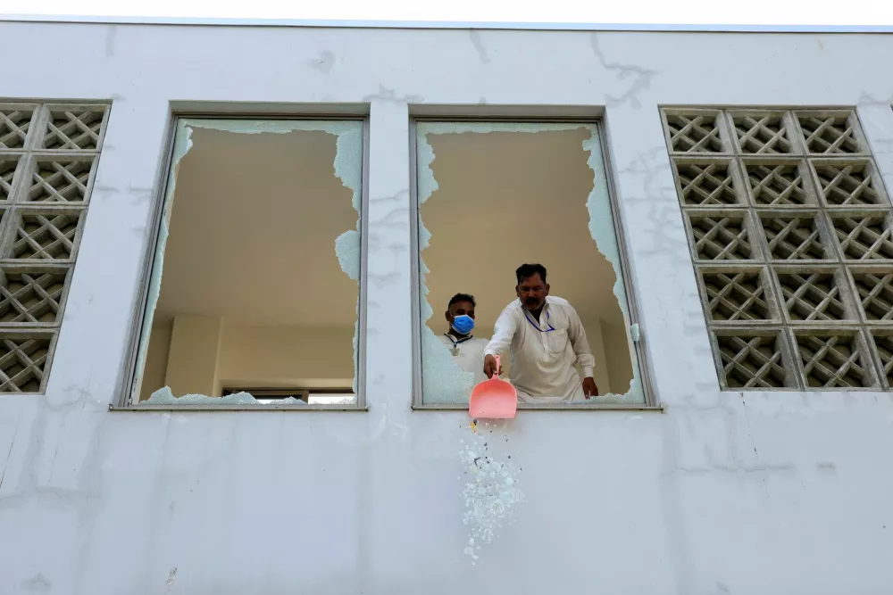 A worker removes broken pieces of a glass window after a fire broke out at the Pakistan Institute of Medical Sciences (PIMS) hospital in Islamabad, Pakistan, August 26, 2026. REUTERS/Akhtar Soomro
